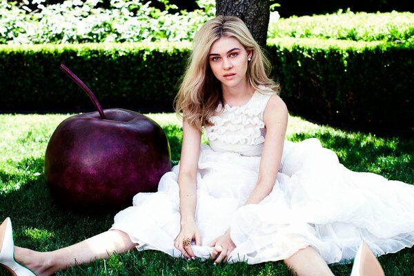 Photo shoot of a girl on the lawn and a big apple