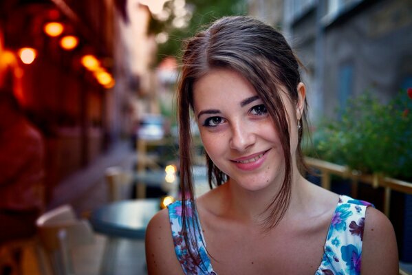 Bella ragazza dagli occhi marroni sorridente sullo sfondo del caffè