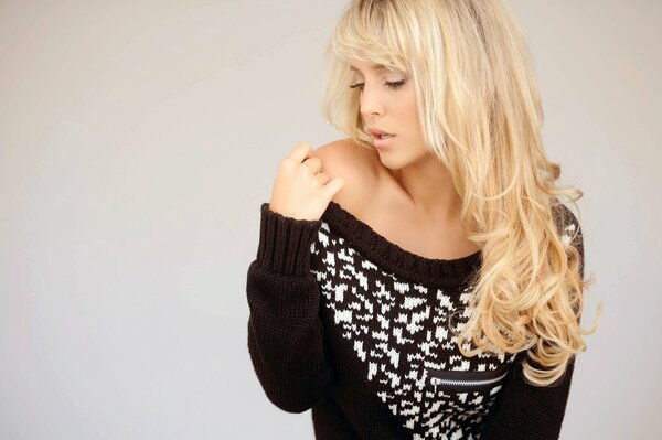 Blonde with a bare shoulder in a black sweater