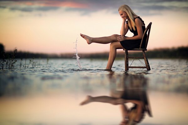 Ein Fotoshooting. Mädchen auf einem Stuhl im Wasser