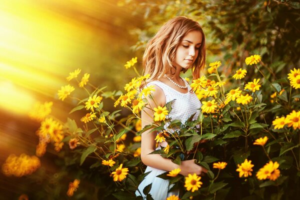Chica en camiseta blanca toca las flores