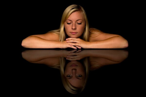 Fille se penche sur le reflet de la table, un regard différent