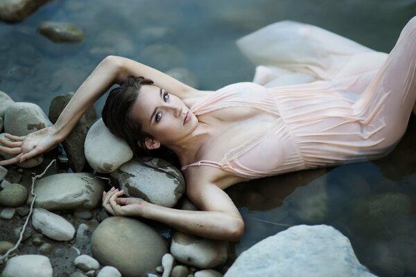 Wet girl lying on the rocks