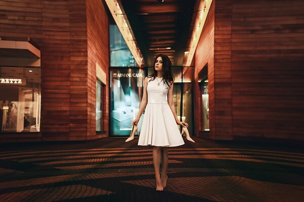 Brünette Mädchen im weißen Kleid mit Schuhen