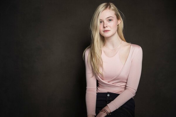 Elle Fanning in una camicetta rosa chiaro