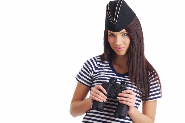 Ragazza in marinaio a strisce con binocolo in mani