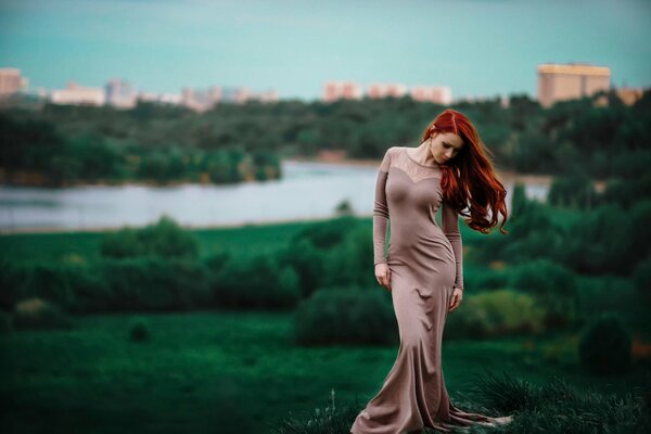 Red-haired beautiful girl in a long dress