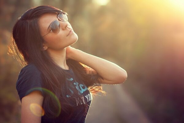 Brunette with glasses on a background of sunlight