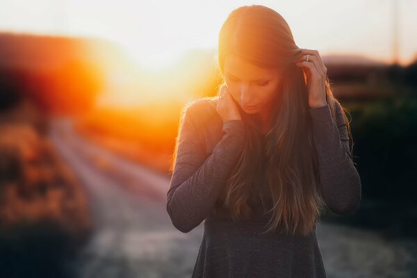 Pensive girl on the background of sunset