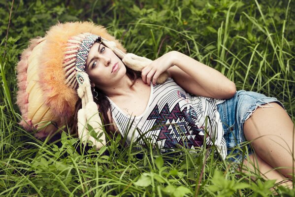 Fille dans la coiffe des indiens sur l herbe