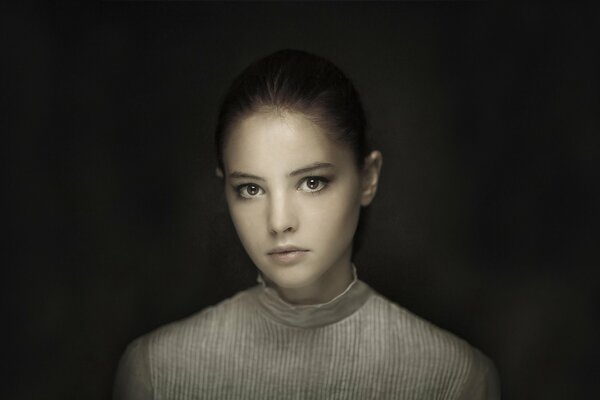 Porträt eines braunäugigen Mädchens auf dunklem Hintergrund