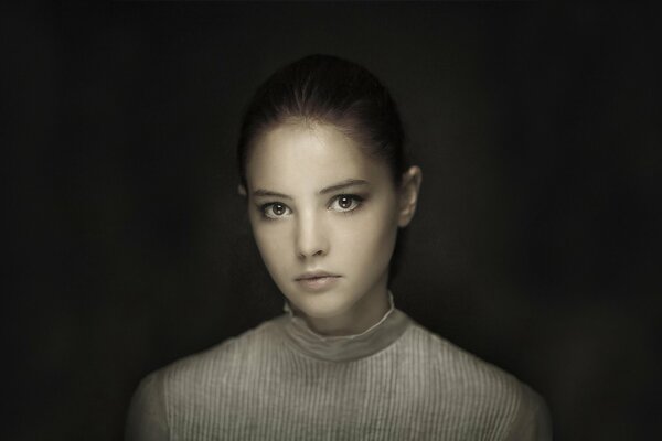 Portrait d une jeune fille aux yeux bruns sur fond sombre