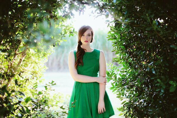 Chica con vestido verde en el fondo de la naturaleza