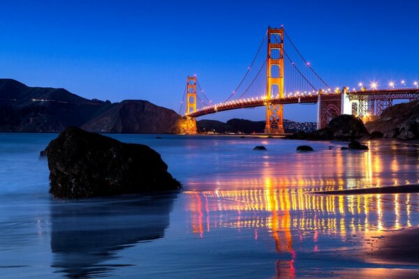Night view of the Golden Gate bridge and its reflection in the water