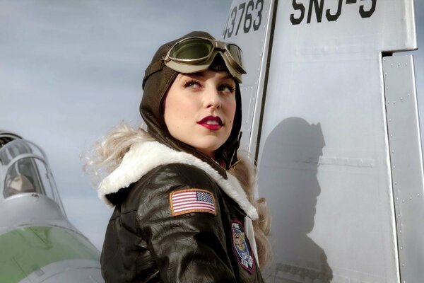 Ragazza in uniforme aeronautica su sfondo grigio