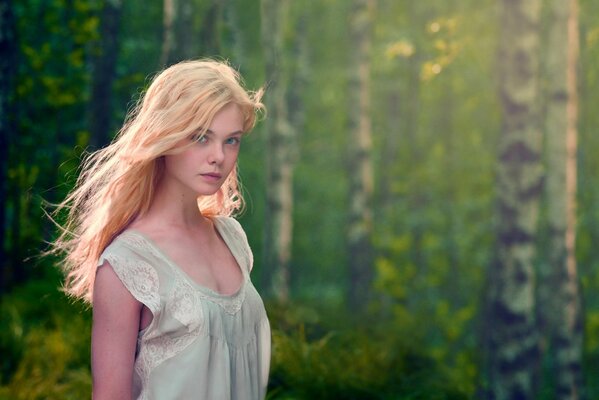 Brooding Ellie Fanning against the background of the forest