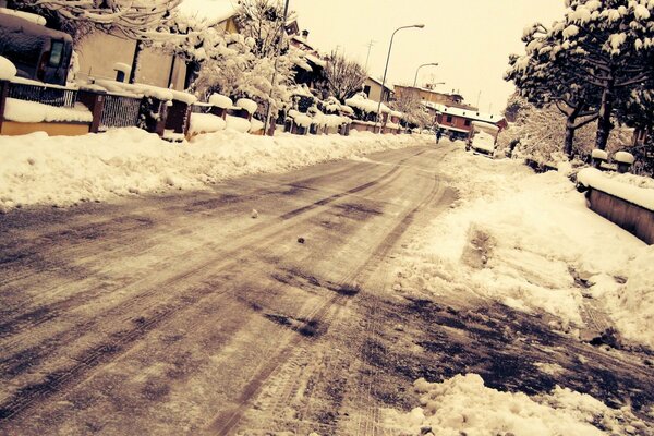 Strada invernale innevata con case