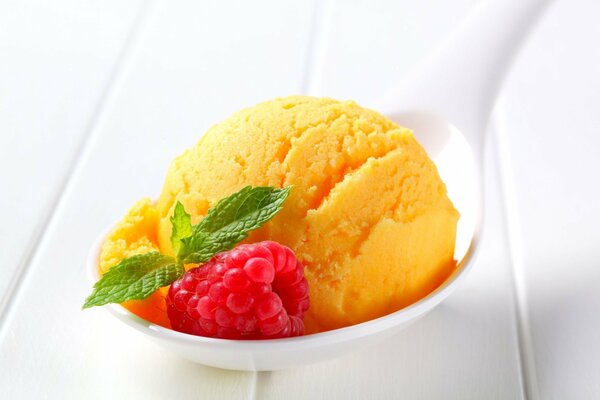 Gelato giallo con lamponi e foglie