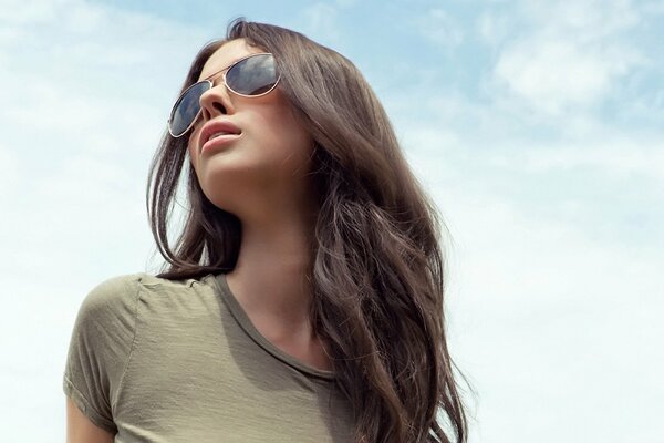 Chica joven con el pelo largo en gafas de sombra