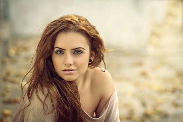 Photo of a beautiful red-haired girl with a bokeh effect