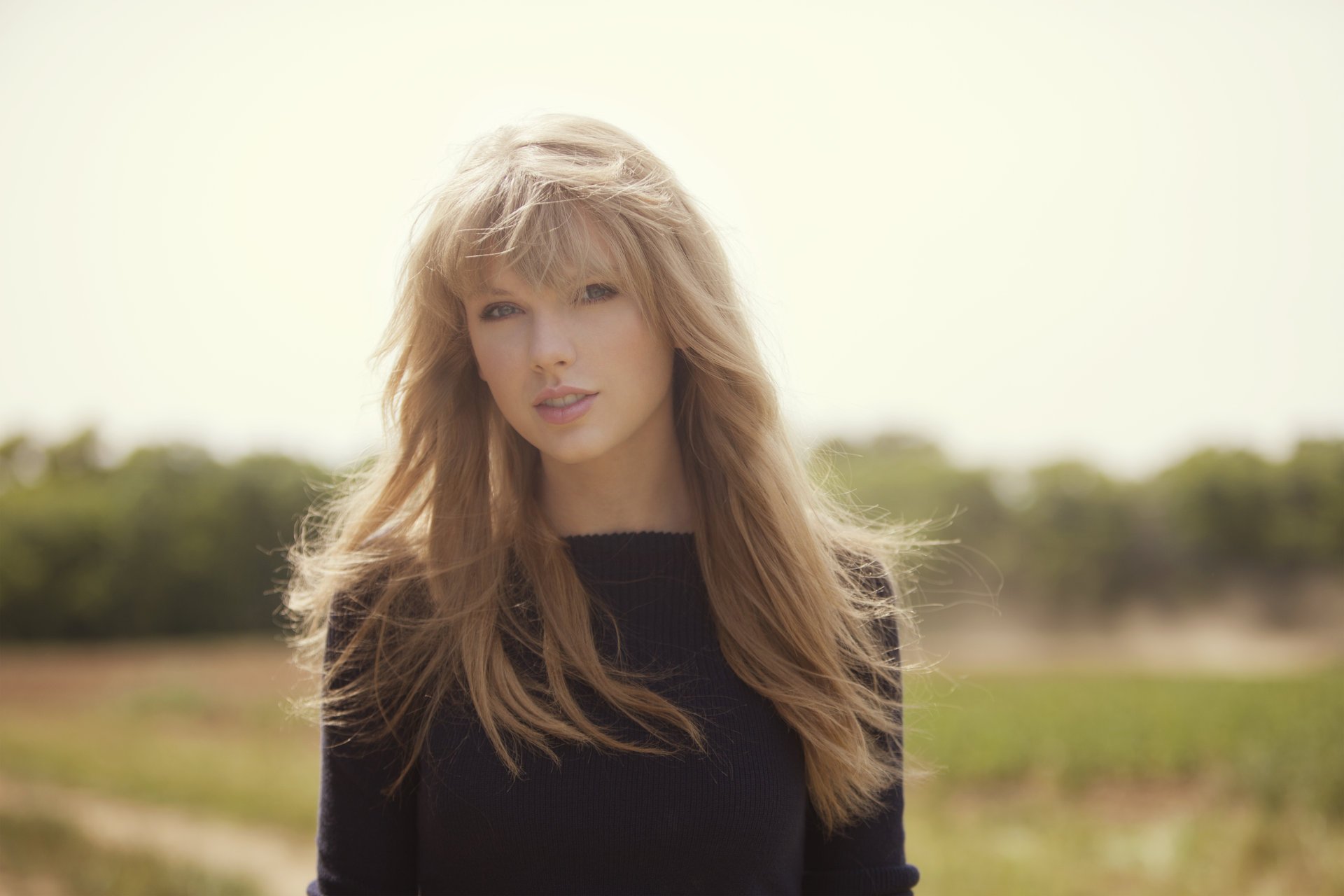 taylor swift rubia cantante cara mirada cabello sol fondo