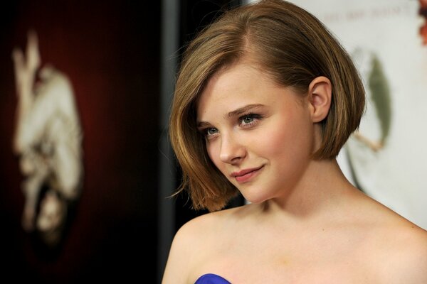 Actress Chloe Grace in a blue dress. Chloe Grace with short hair