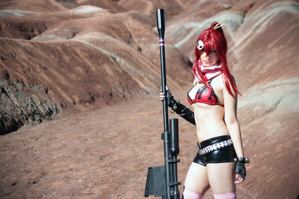 Девушка косплеер на фоне пустыни в коротких шортах и с огромной винтовкой
