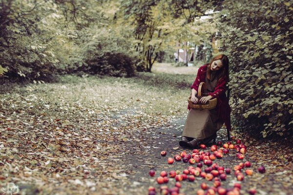 La jeune fille a dispersé les pommes et est triste