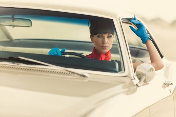 Fille avec des gants sur la voiture