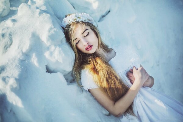 Sleeping girl in winter in the snow