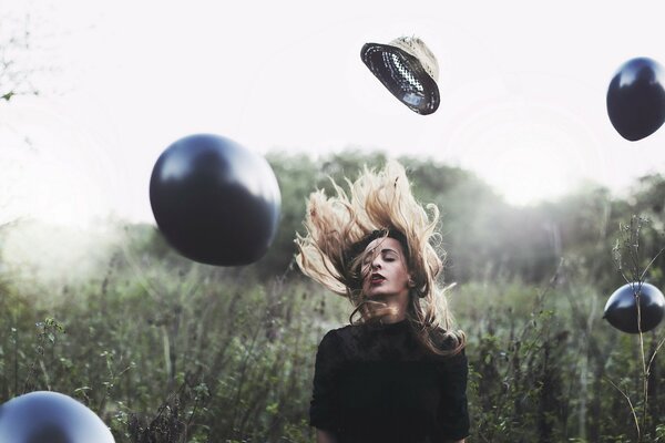 Fille avec un chapeau sur un fond de boules noires