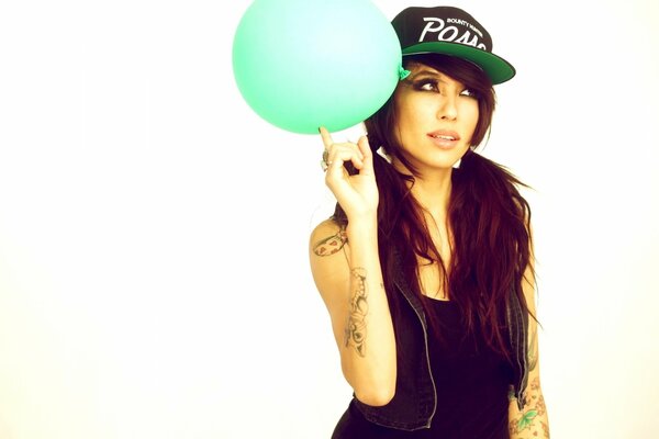 Brunette in a cap and with a balloon in her hand