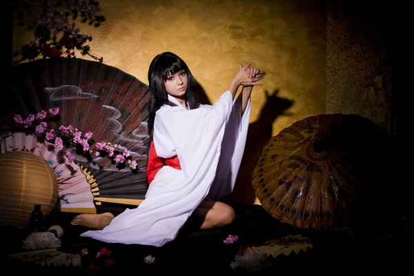 A girl in a kimono with a fan and an umbrella