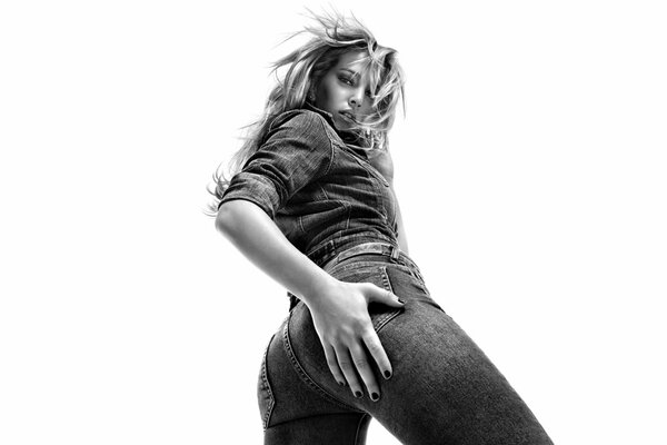 Una chica en una pose interesante Mira directamente a la cámara en una foto en blanco y negro