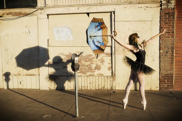 Ragazza ballerina sulla strada con ombrello