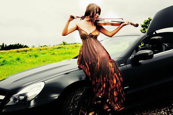 Jouer du violon sur le capot de la voiture