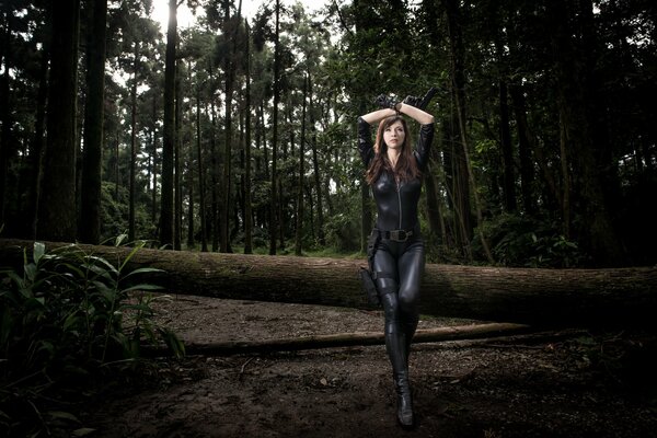 Ragazza con la pistola nella foresta oscura