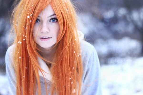 Red-haired girl on the background of snow