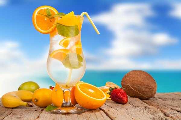 Orangencocktail neben Früchten