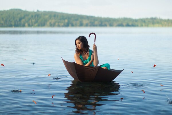 Niña nadando en el lago en un paraguas