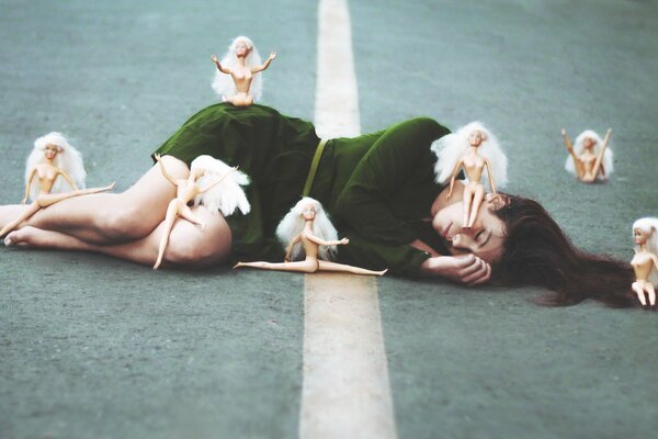 Sleeping girl surrounded by dolls