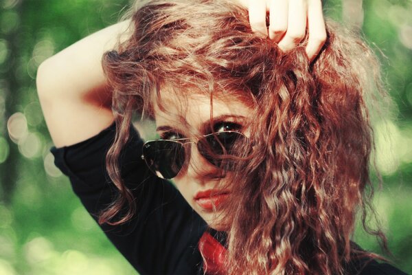 Red-haired, curly-haired girl with glasses