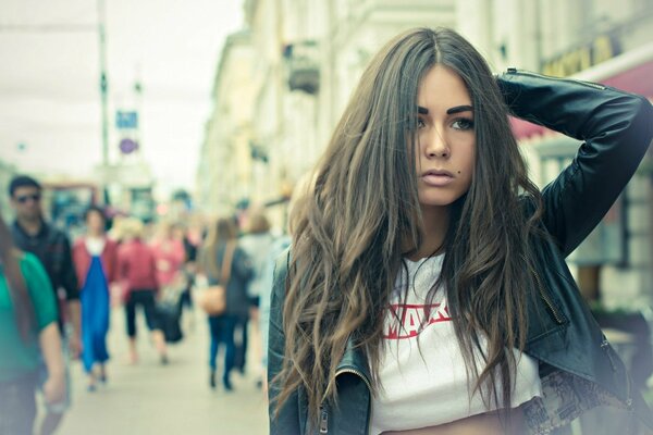 Chica con el pelo suelto en la calle de la ciudad