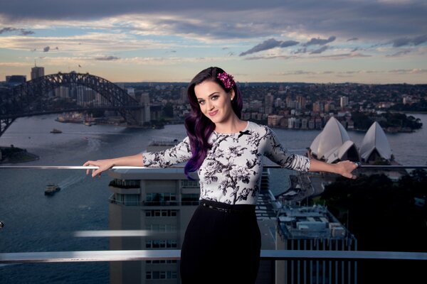 Sourire de Katy Perry avec des cheveux violets sur fond de ville