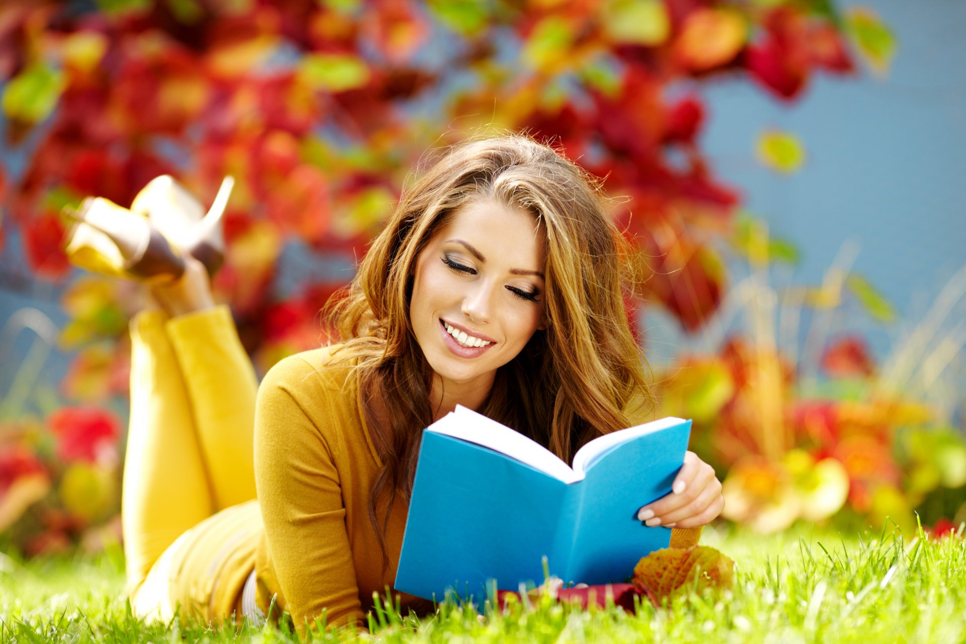 girl brown hair smile book reads autumn grass leave