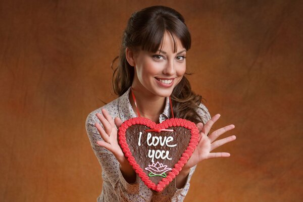 Jeune fille brune avec un coeur dans les mains