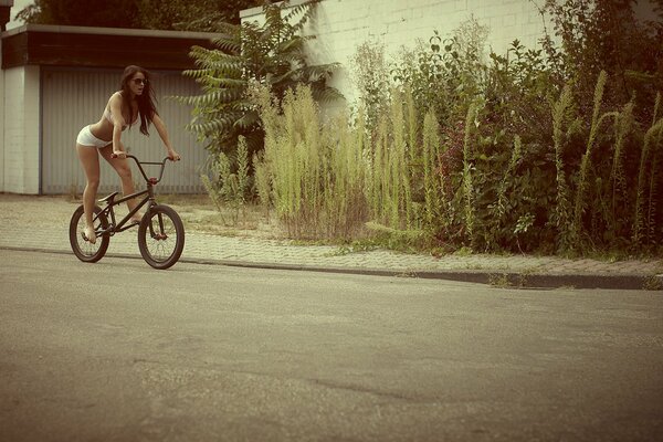 Девушка в нижнем белье едет на велосипеде