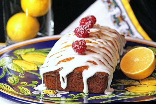 Sweet cake decorated with icing and raspberries