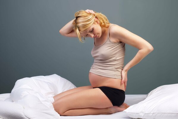 Pregnant blonde sitting in bed