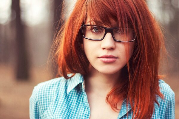 Rousse fille avec des lunettes et une chemise